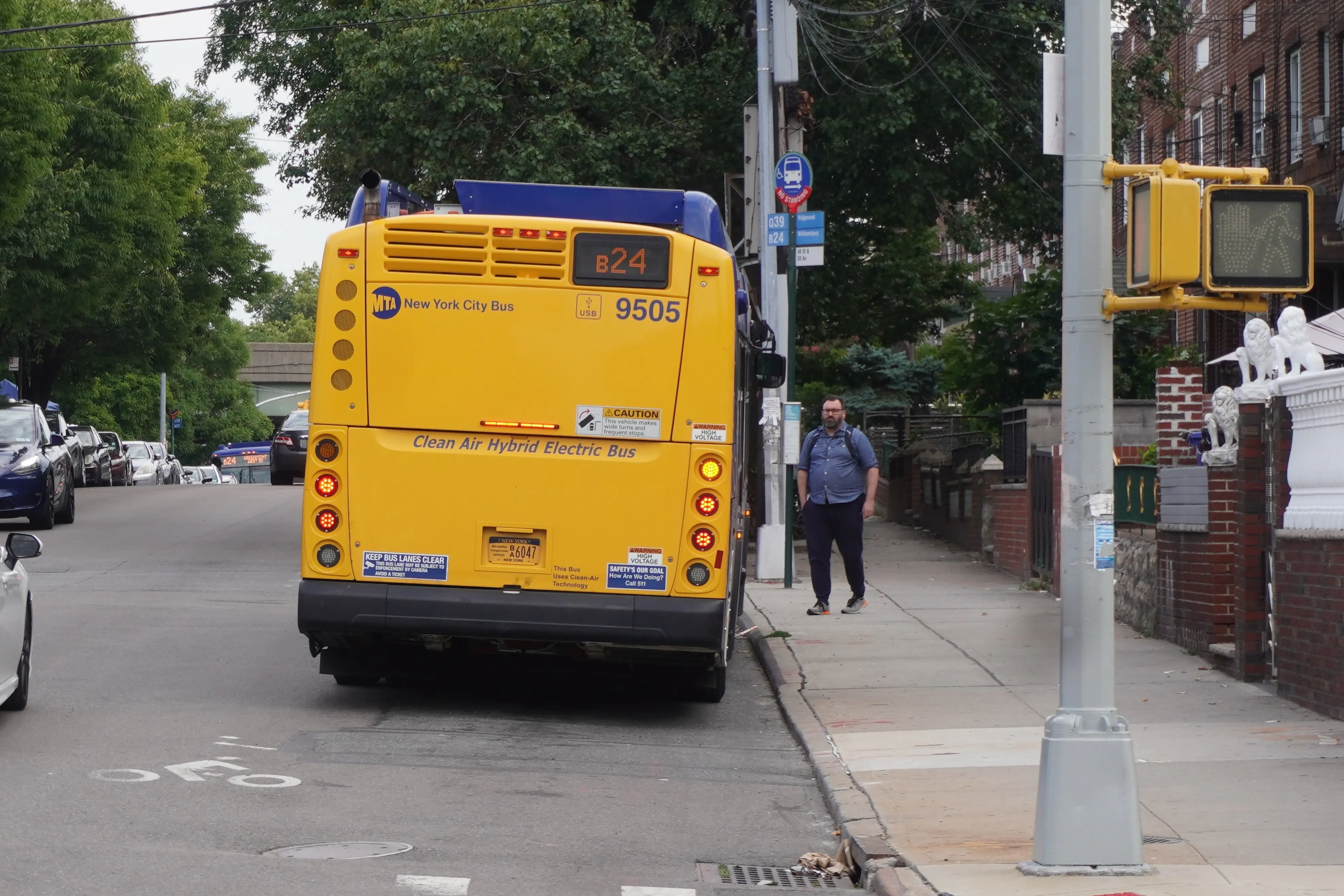 A person waits for a bus as it approaches the stop